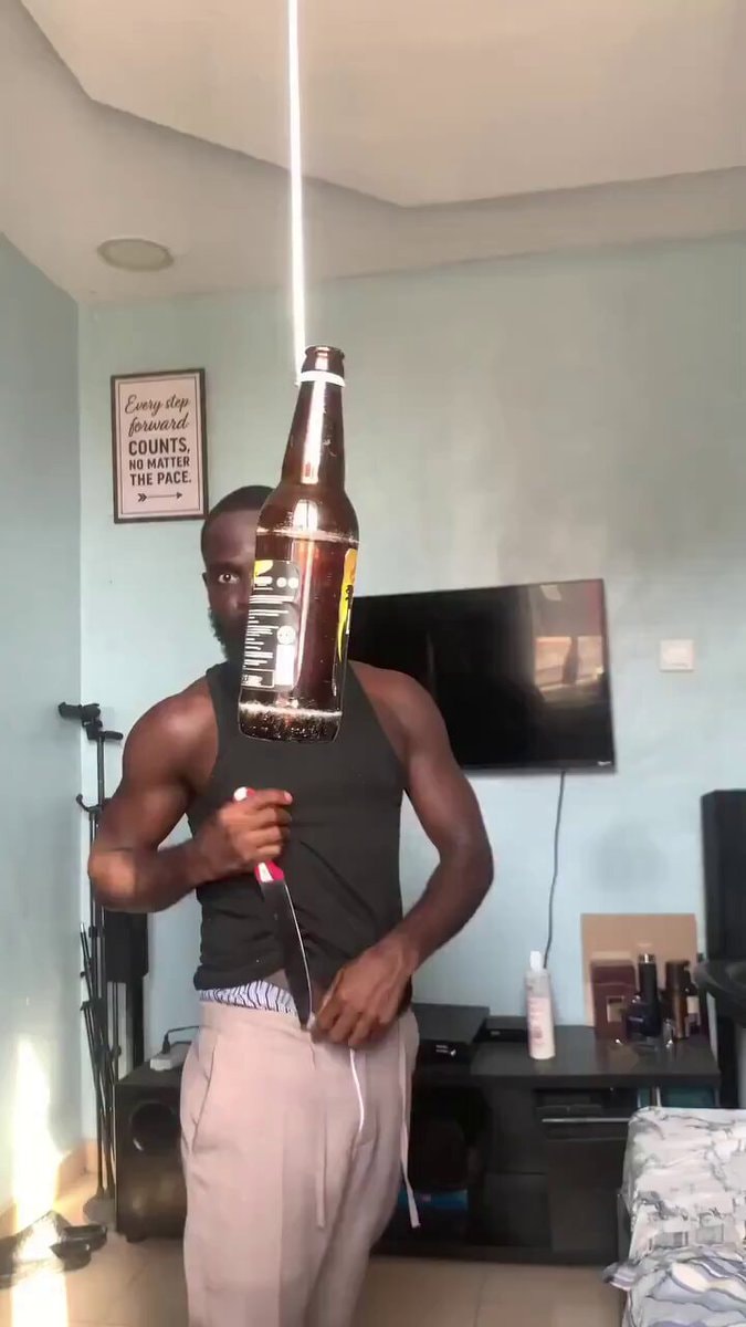 Man cutting suspended beer bottle