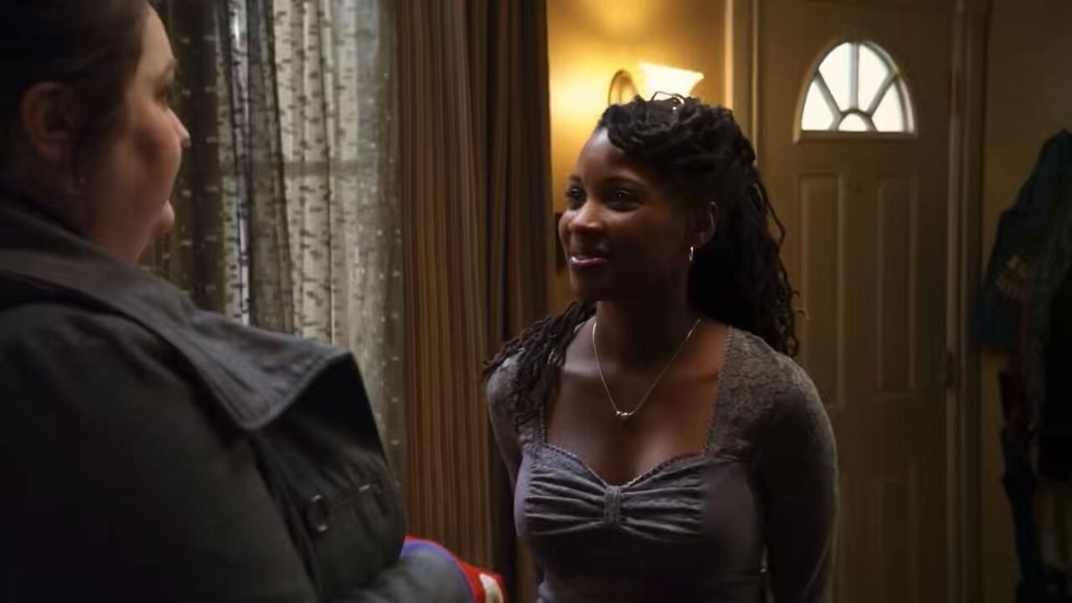 Two women talking in a dimly lit room