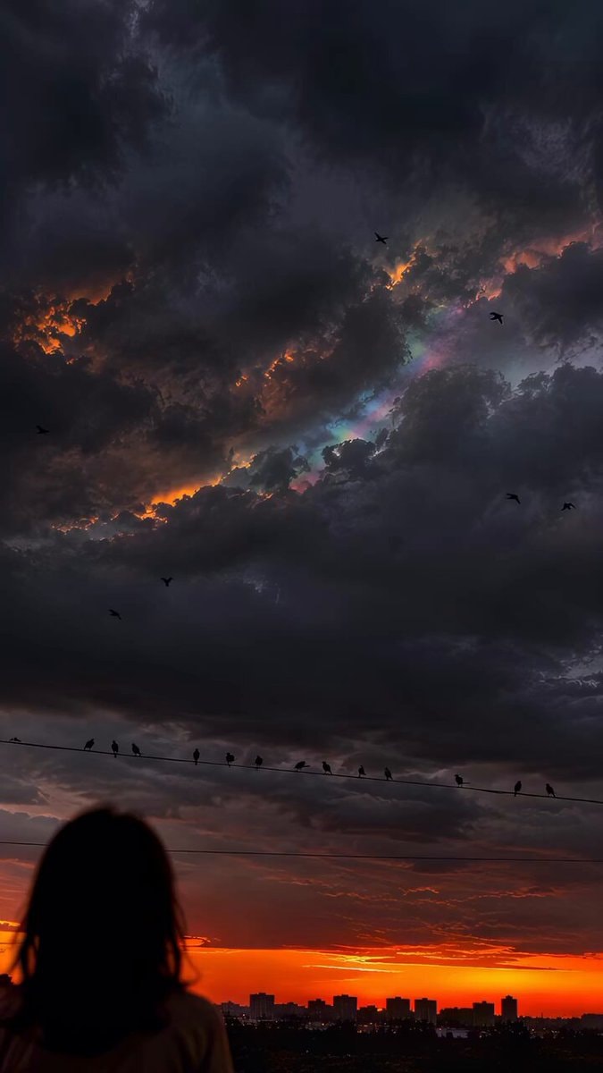 rainbow light through storm clouds at sunset