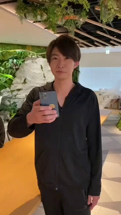 Man holding phone with yellow charm