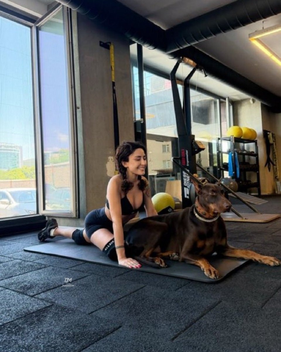 Melek Mosso gym stretch with Doberman (photo 2 of 2)