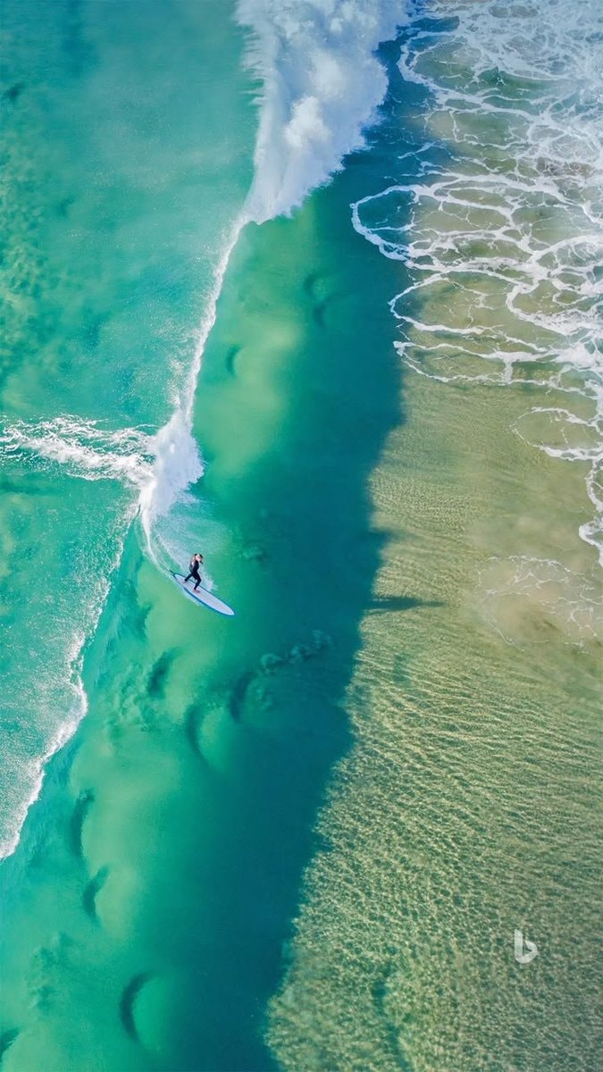 Surfer riding a turquoise barrel wave (photo 2 of 2)