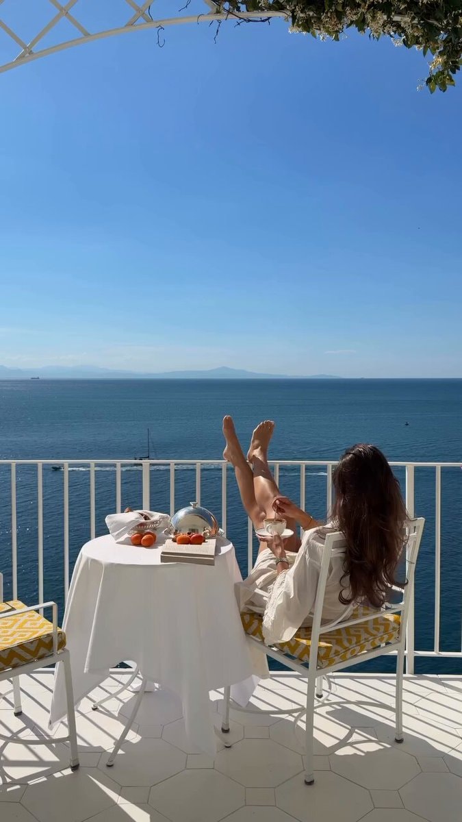 Woman relaxing on balcony with ocean view