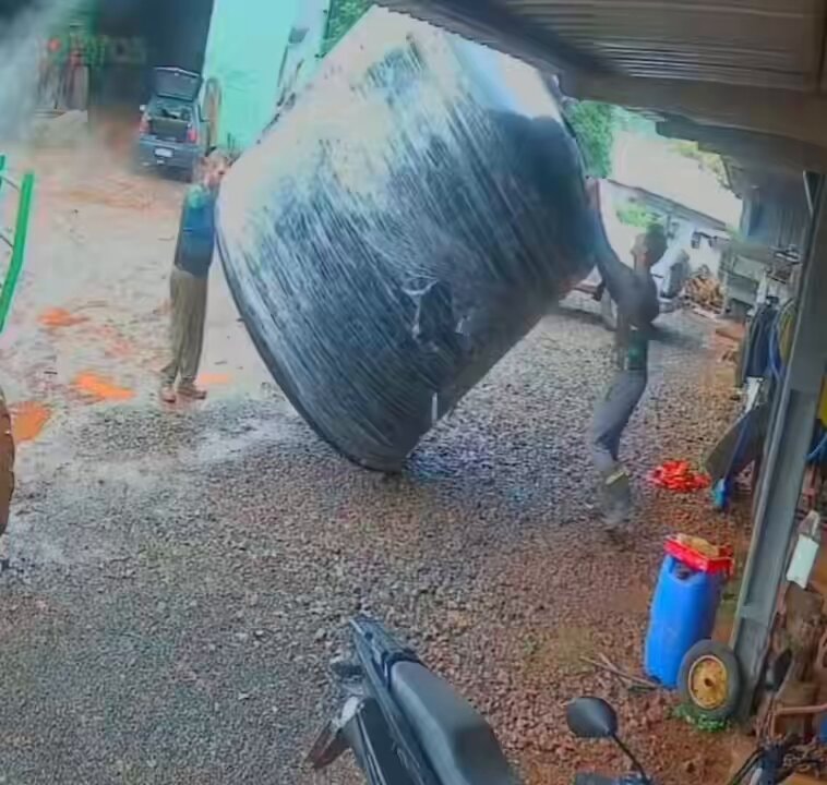 Two guys moving a big wrapped cylinder