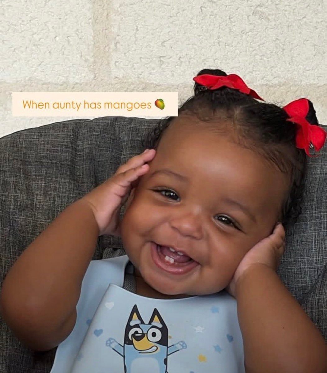 baby doll with Bluey bib and mangoes