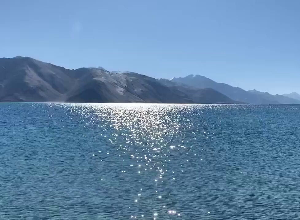 Sun glittering on lake with mountains