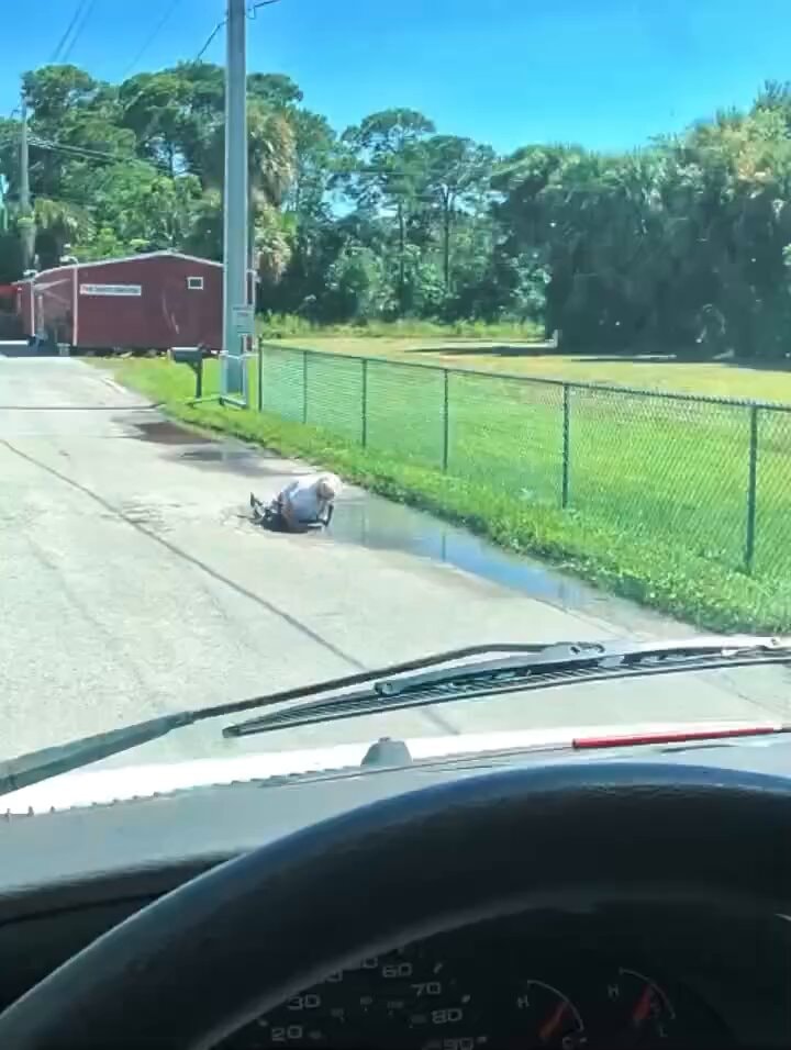 Man helps elderly woman from puddle