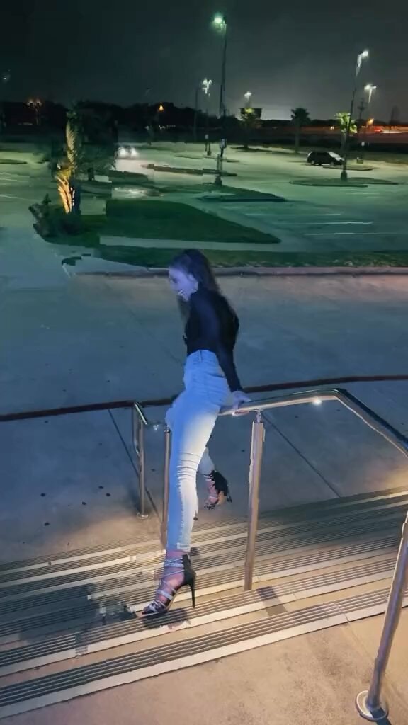 young woman on railing at night