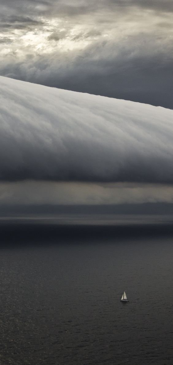sailboat under storm clouds