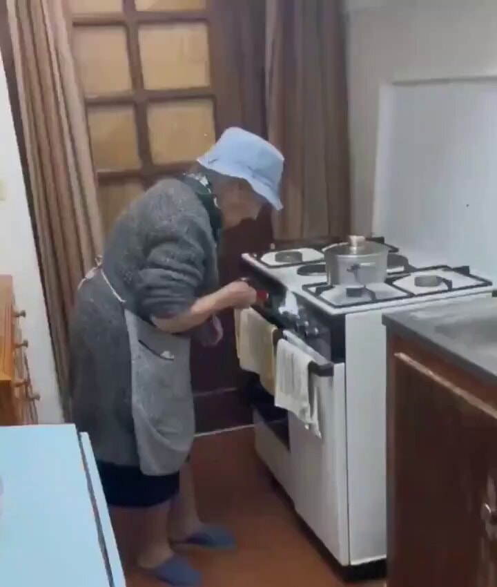 grandma checking stove with flashlight