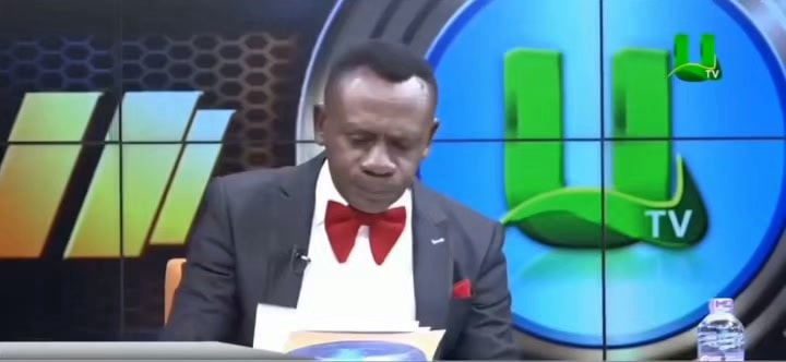 Man in suit and red bowtie on TV
