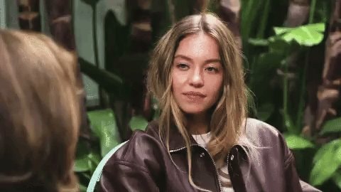 Blonde woman in leather jacket reaction