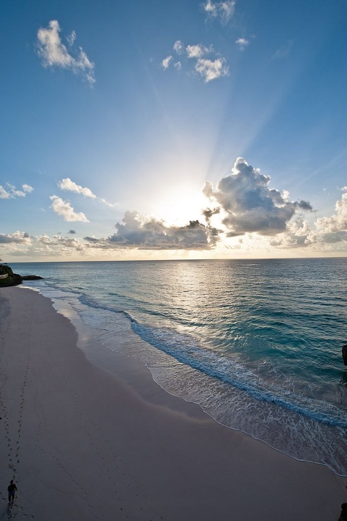 lone person walking on beach at sunset