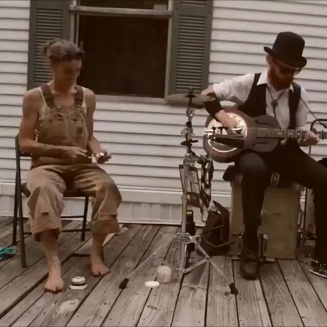 Outdoor folk duo performing on a wooden deck