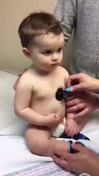 Baby at nine-month checkup rests head on nurse's arm