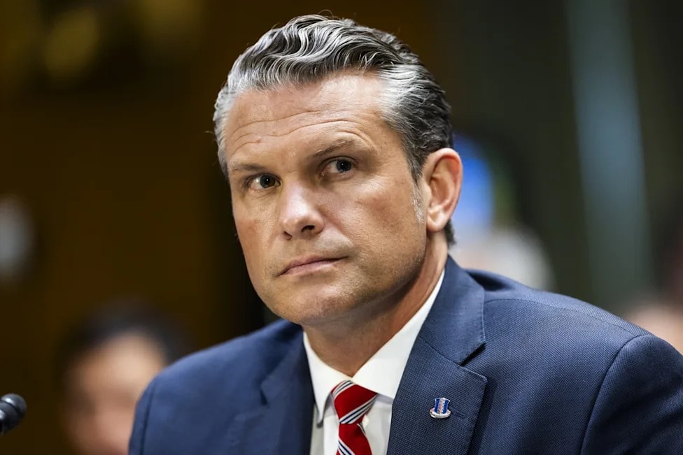 Sec. Hegseth serious expression navy suit