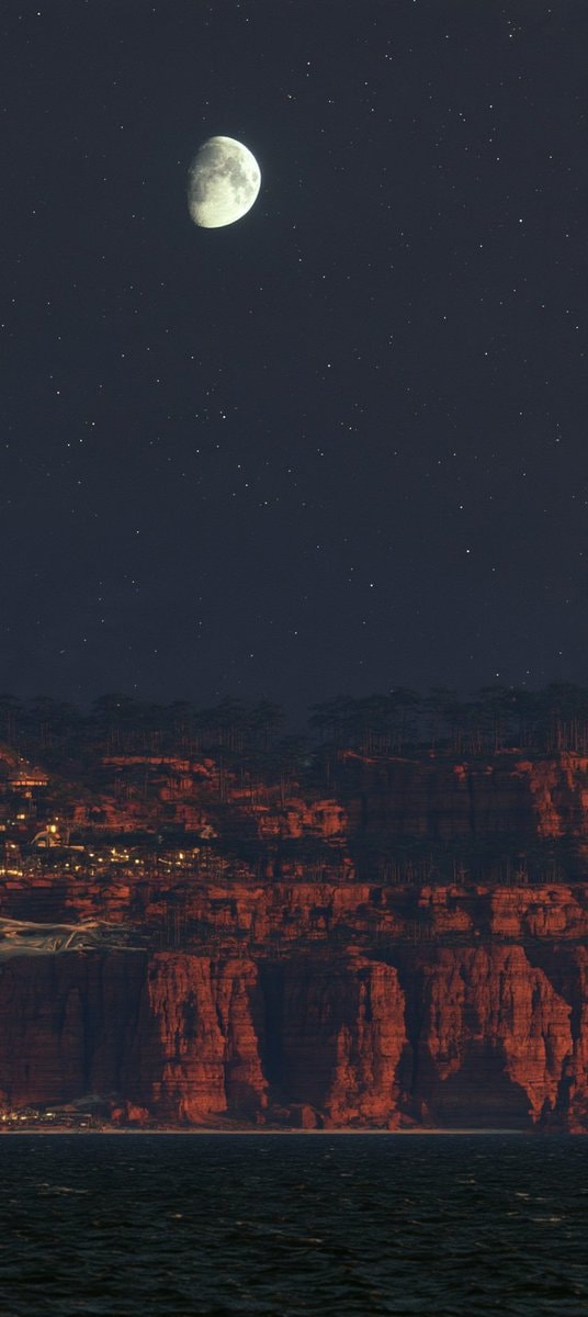 stone statue holding cliff with village lights (photo 4 of 4)