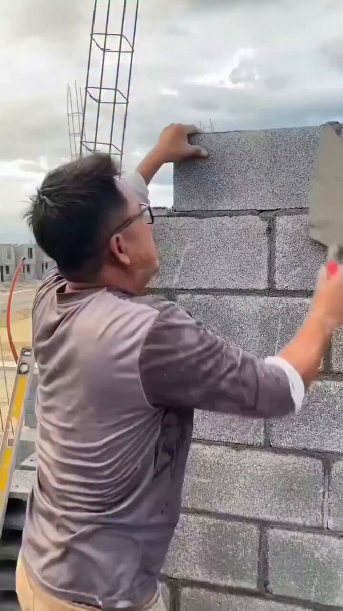 construction worker laying cinder block