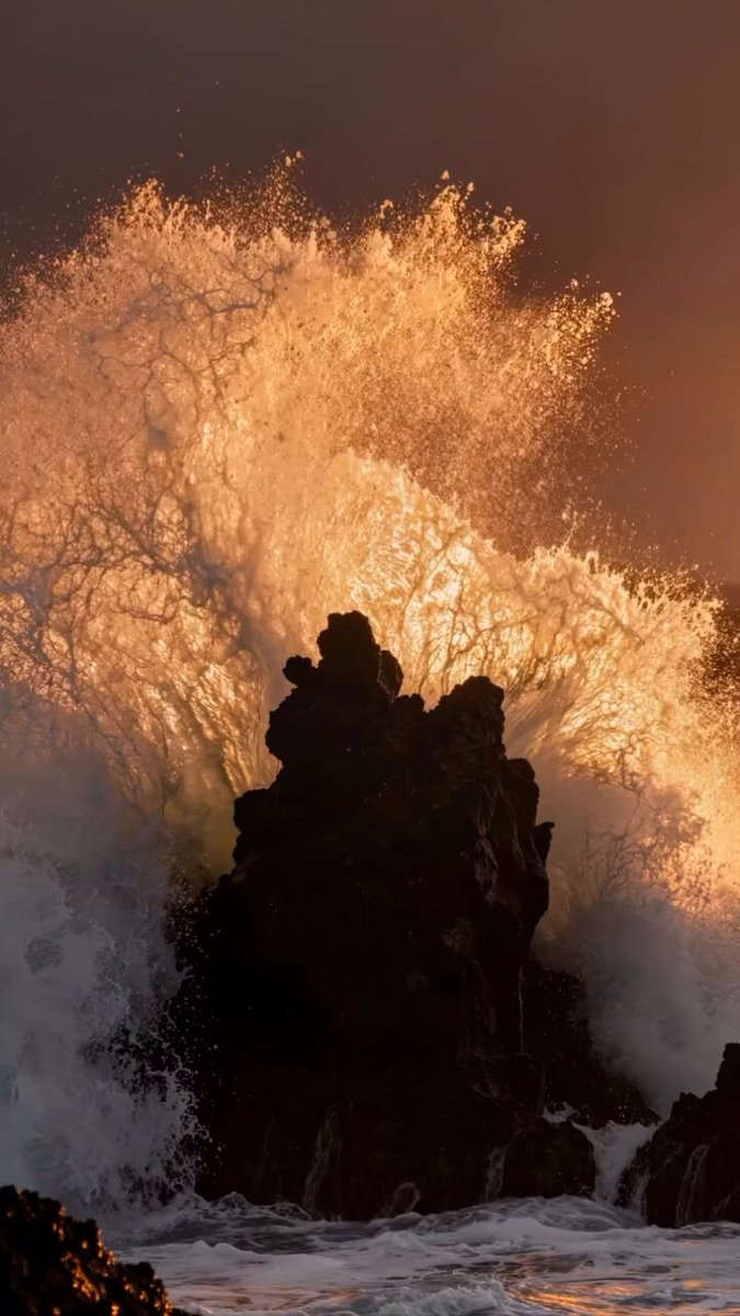Dramatic ocean wave crashing against rocks