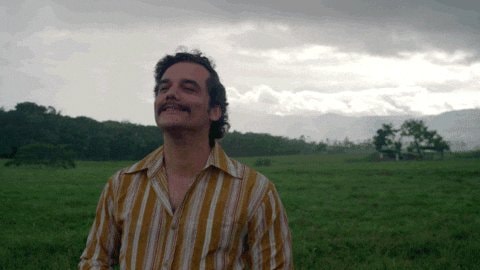 Man in striped shirt on green field