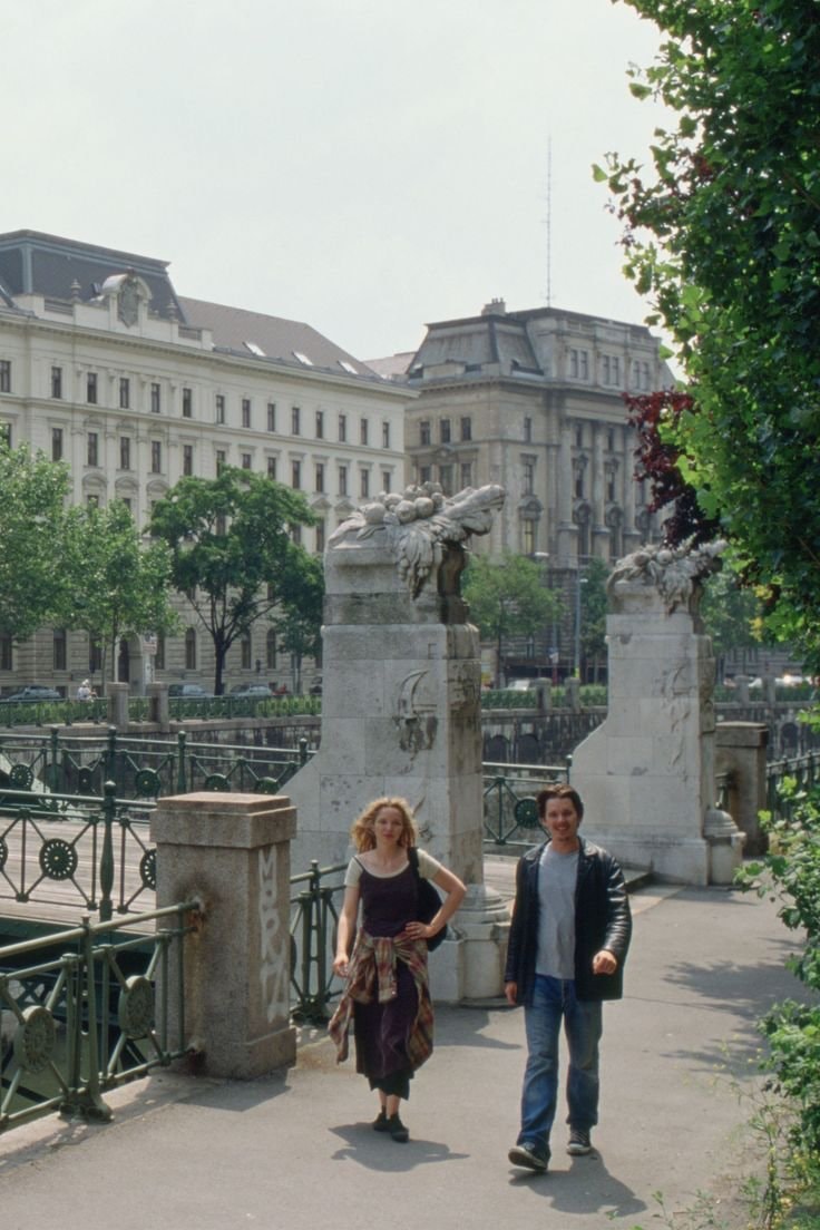 couple walking past ornate stone pillars