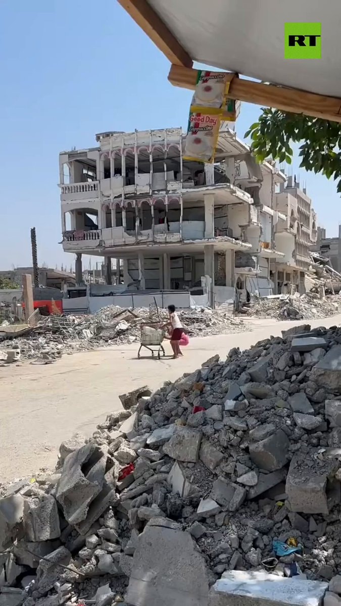 Palestinian children take cover behind shopping cart