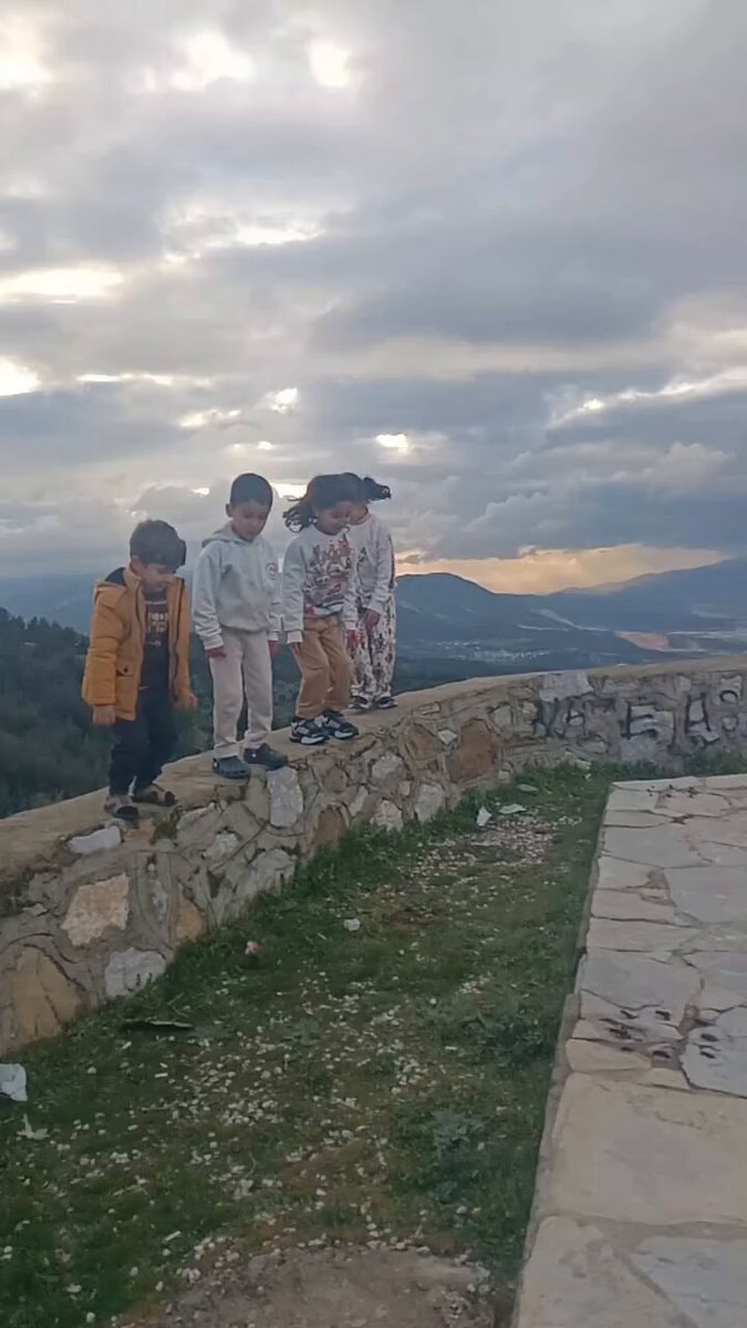 kids standing on stone wall
