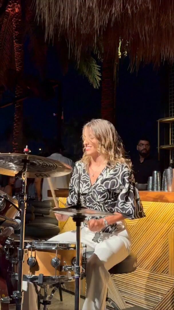 Woman plays drums at outdoor bar