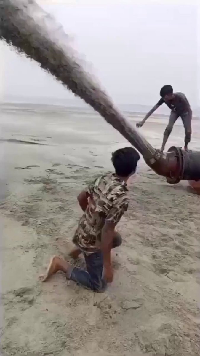 boys and industrial pipe on beach