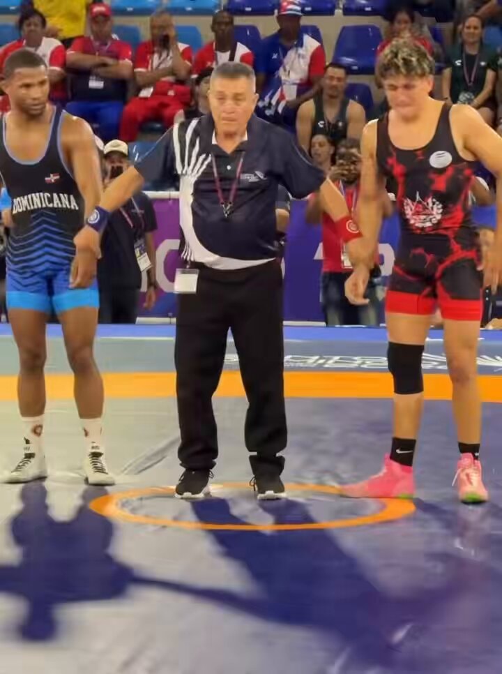 Wrestler carries injured opponent off mat
