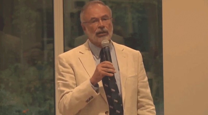 older man speaking into microphone