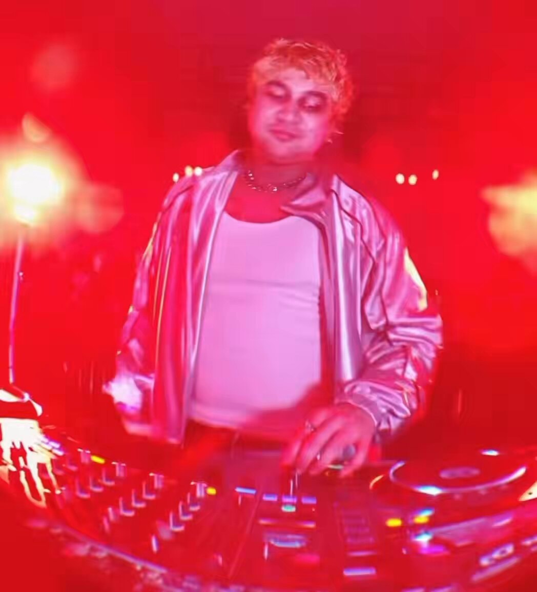 DJ blonde hair silver jacket red lights