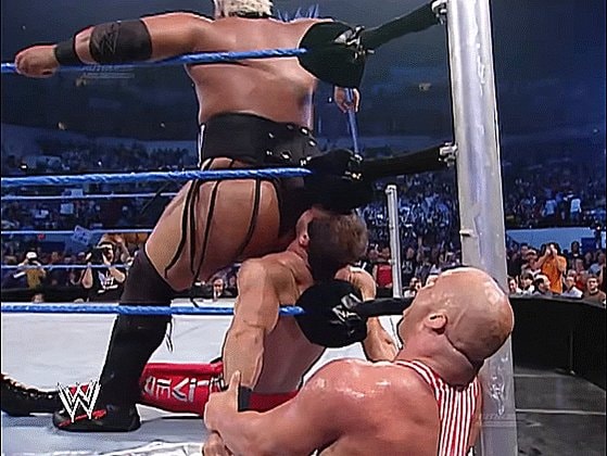 WWE wrestler standing over opponents