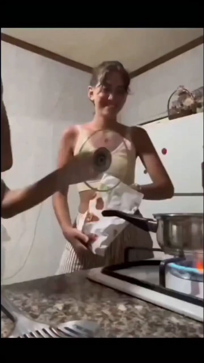 woman in kitchen holding pot lid