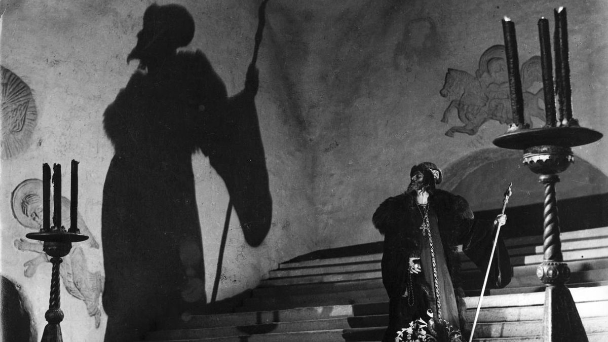 Dramatic figure on staircase with staff