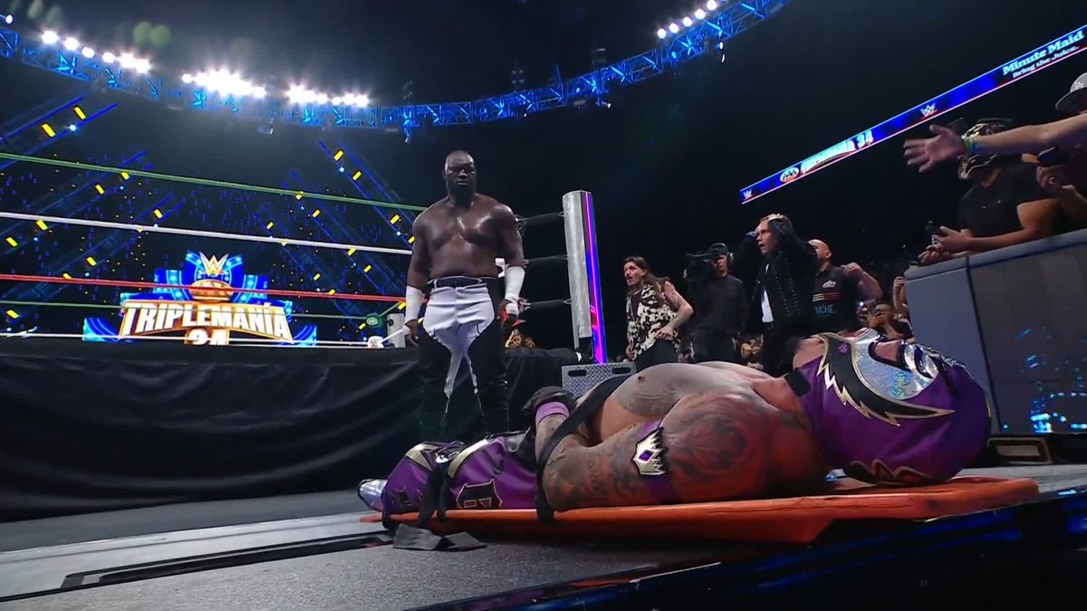 Omos chokeslams Rey through announce table at AAA Triplemania Omos chokeslams Rey through announce table at AAA Triplemania