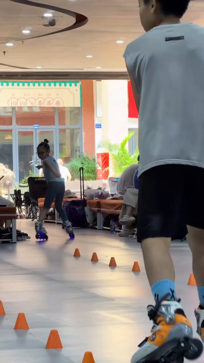 Girl rollerblading through cones