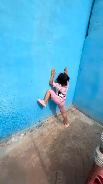 girl climbing blue wall