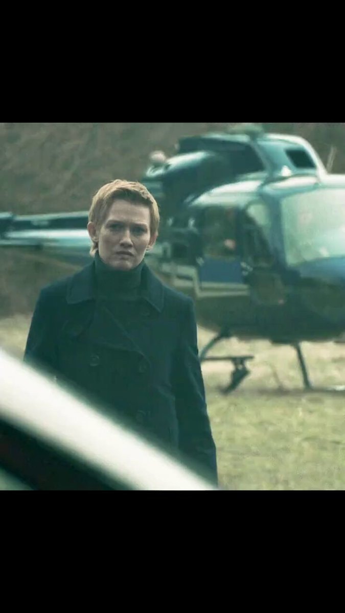 man with blonde hair in front of helicopter