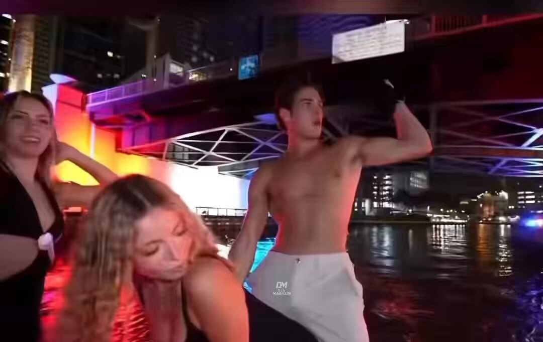 Shirtless man dancing with two girls