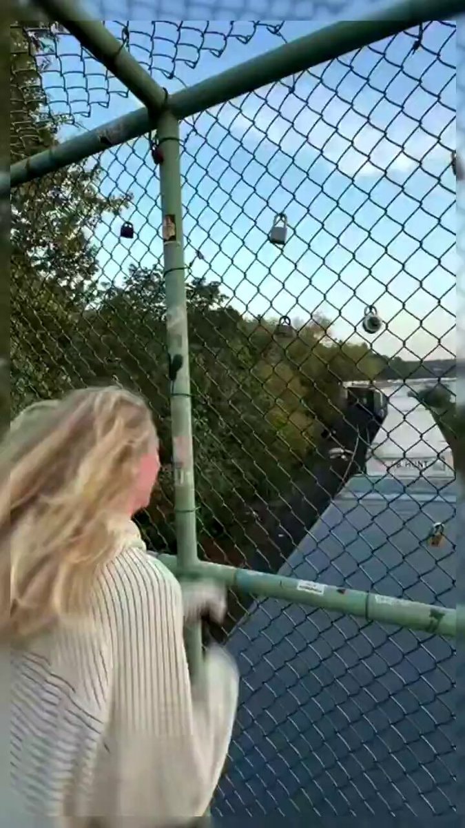 Girl walking on bridge with padlocks