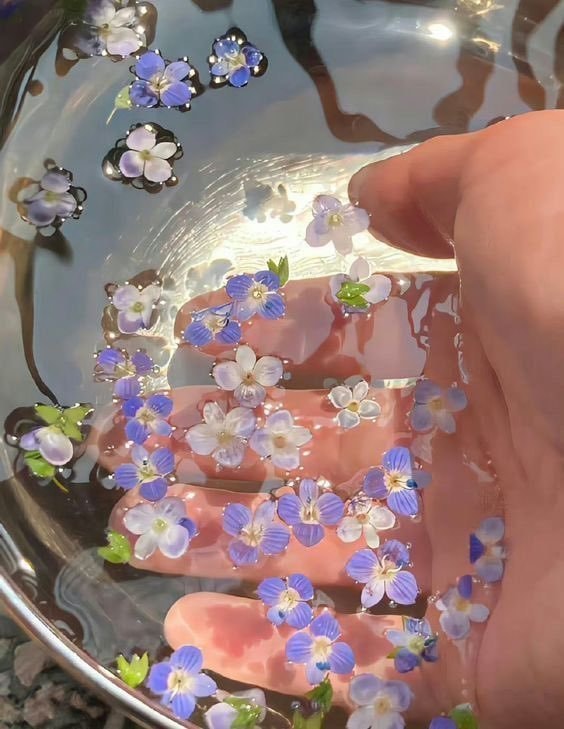 hand with purple and white flowers
