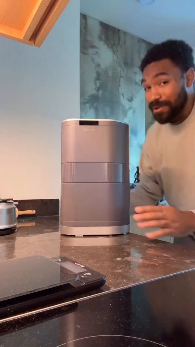 man next to grey kitchen appliance