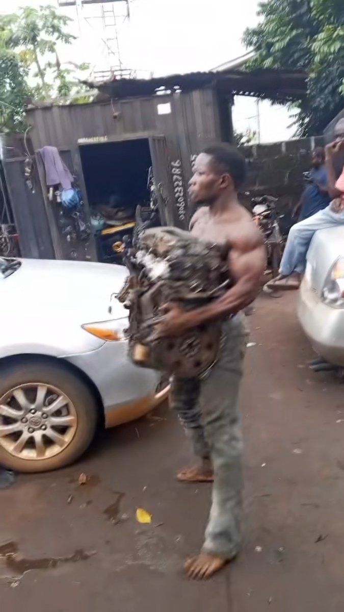 Nigerian mechanic lifts car engine