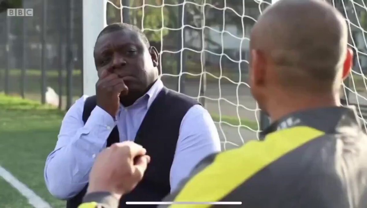 Two men on soccer field with BBC logo