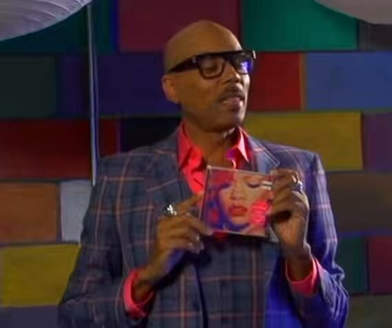 bald man with glasses holding CD case