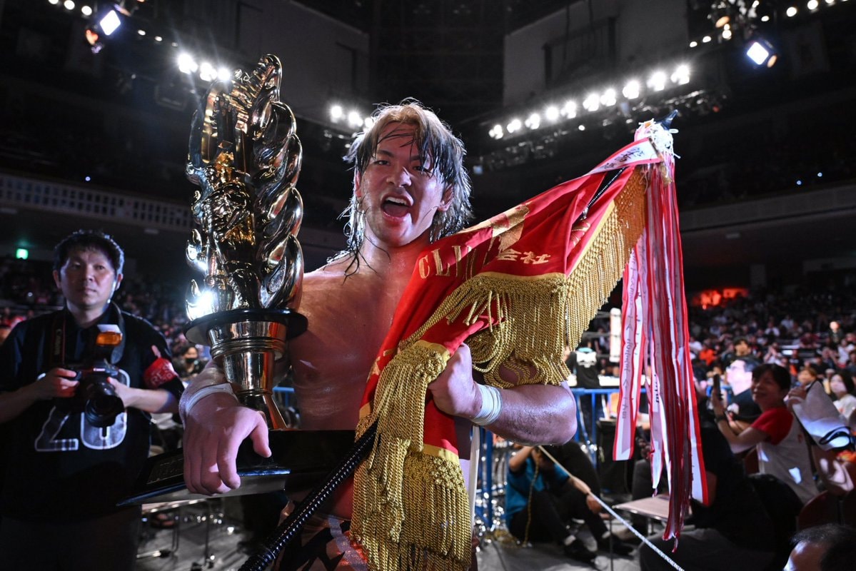 Wrestler holding trophy and flag