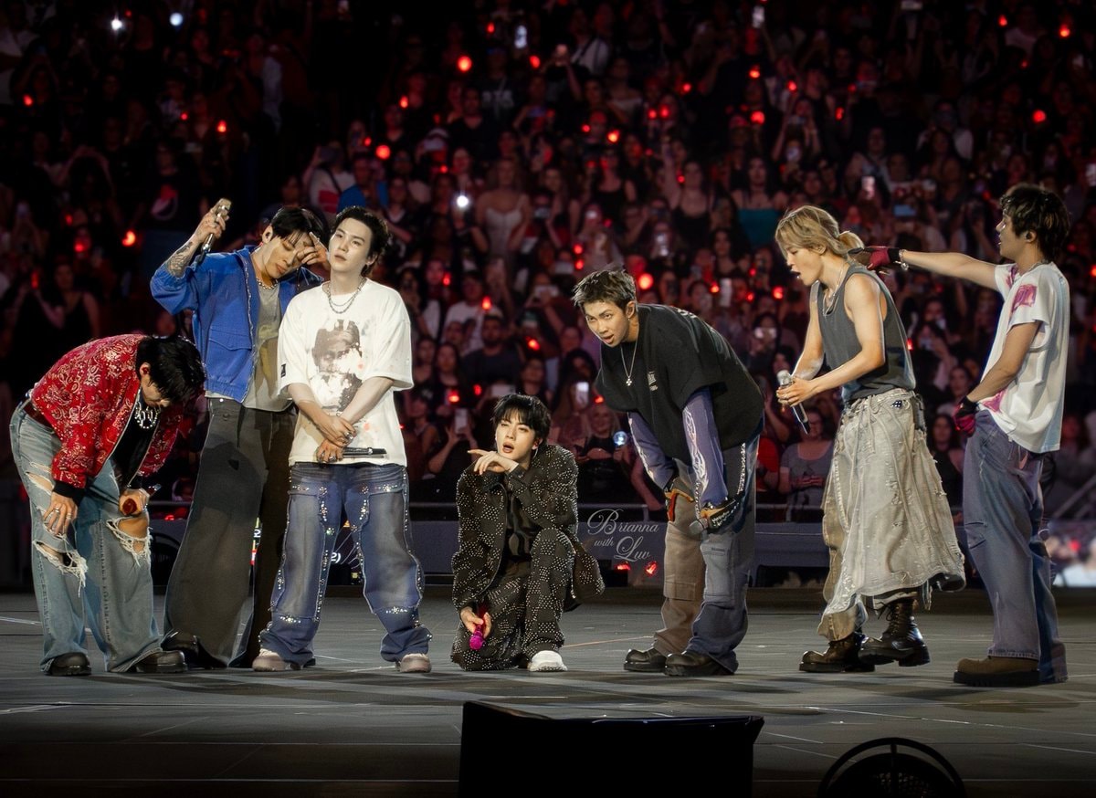 BTS group shot with blonde woman on stage