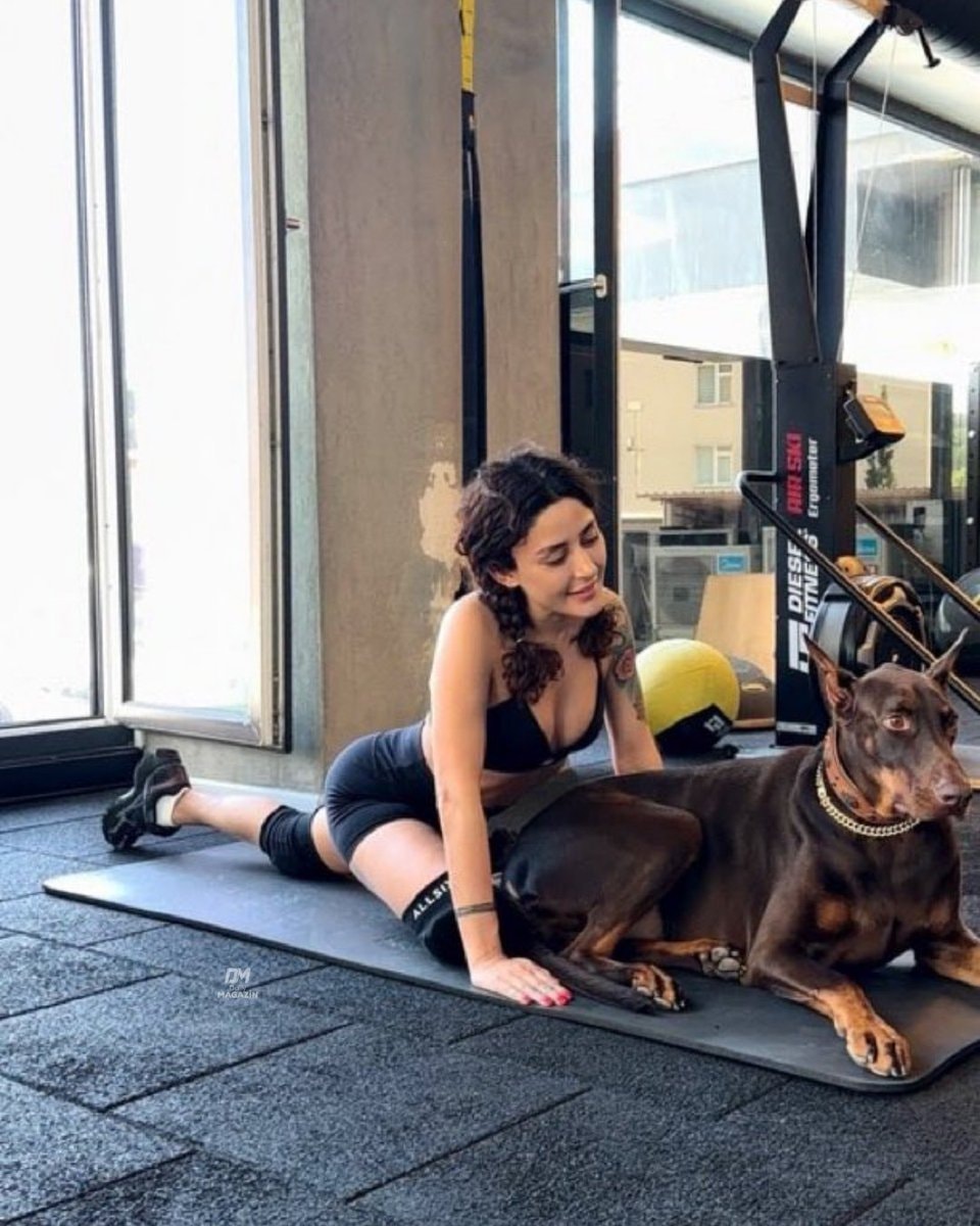 Melek Mosso gym stretch with Doberman