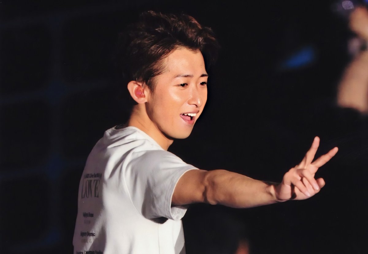 young man on stage peace sign